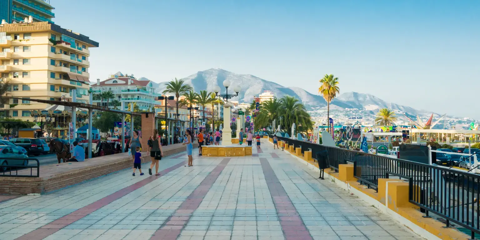 Strandpromenaden i Fuengirola med leilighetsbygg, palmer og fjell i bakgrunnen